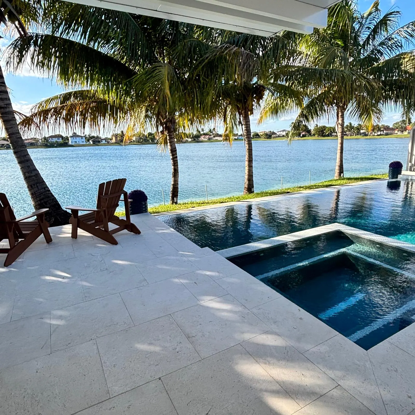 Raised spa spilling into a lakefront pool