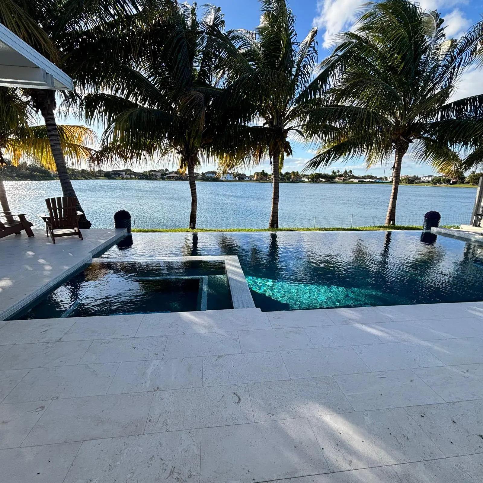 Lakefront custom pool and spa with palm trees at sunset in Miami-Dade