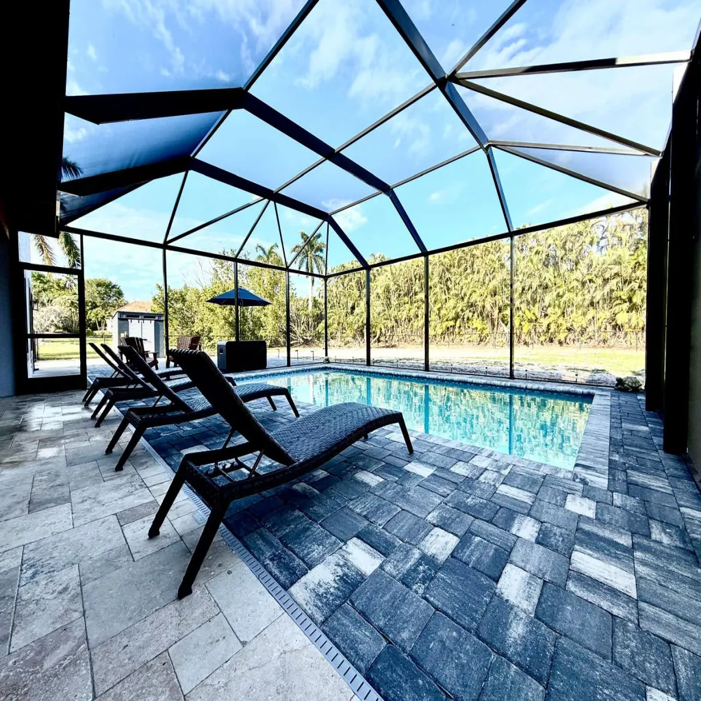 Travertine deck around a pool under a lanai