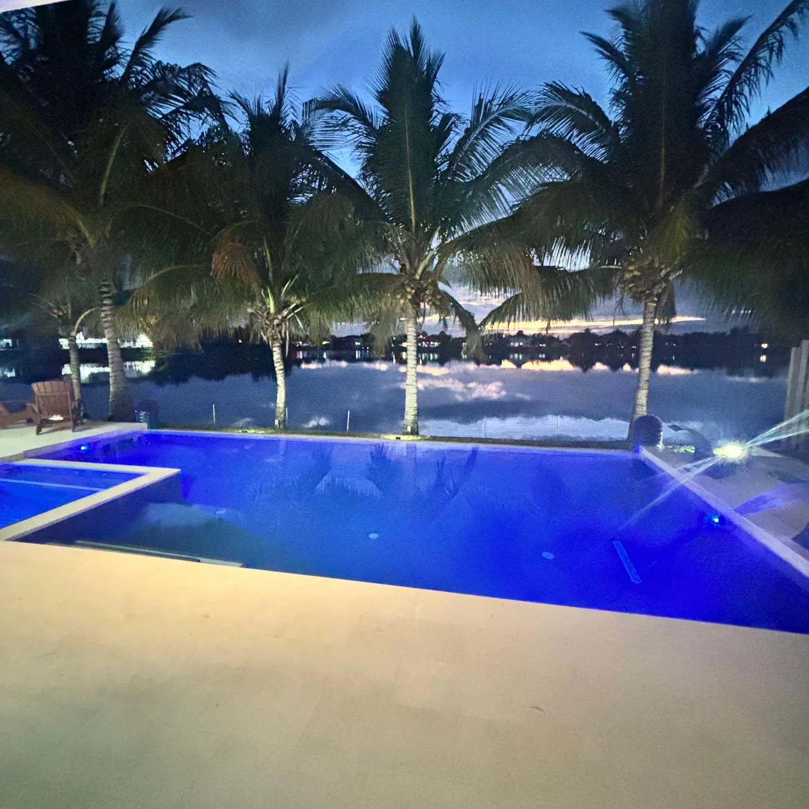 Lakefront pool and spa glowing at night